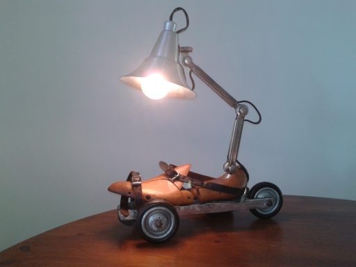 Lampe à posée faite d'un Embauchoir monté sur patin à roulette 3 roues surmonté d'une lampe vintage de type industriel.
