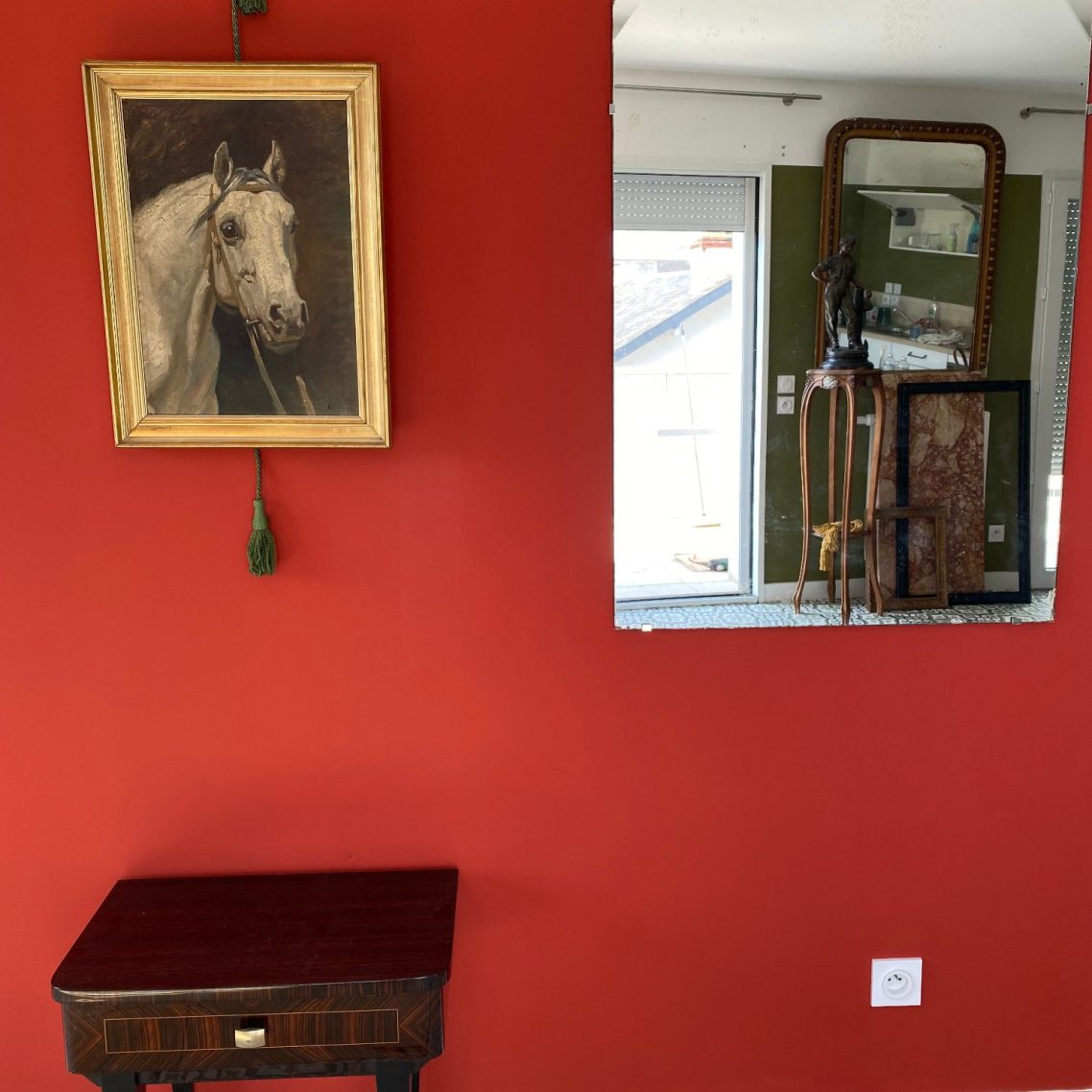 Photo d'une huile sur toile (cheval), un meuble de style,  un miroir dans lequel se reflètent une sellette, une statuette et un trumeau
